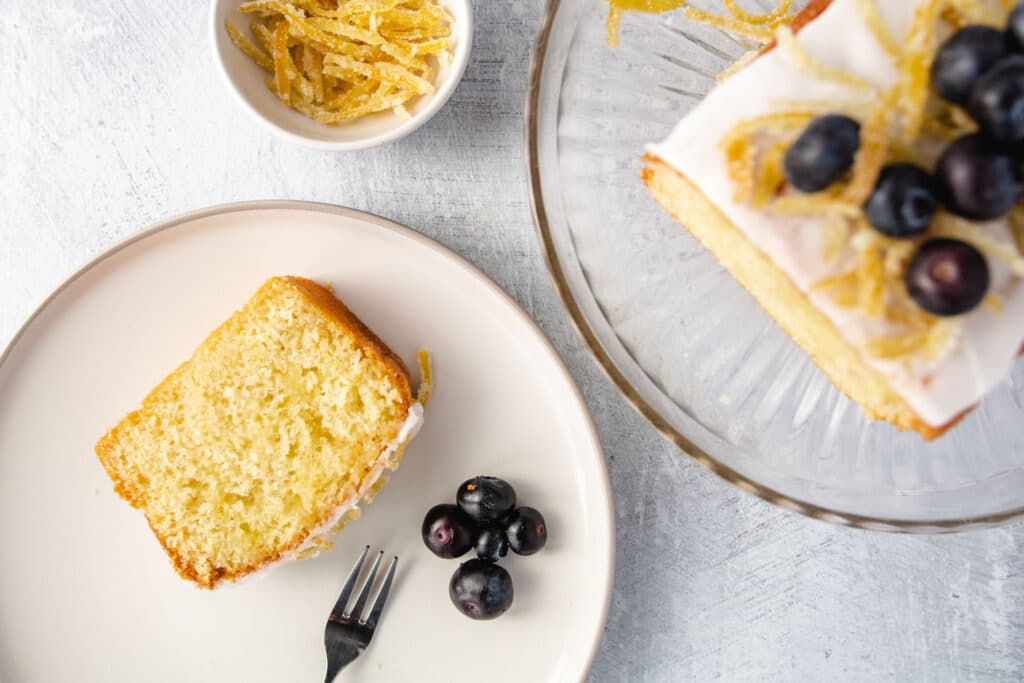 Slice of lemon cake on a plate with blueberries
