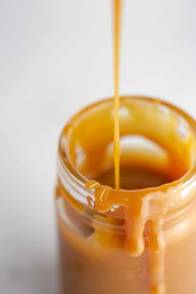 Salted caramel sauce being drizzled into a jar version 2