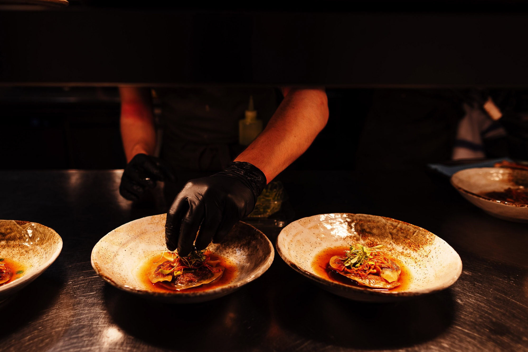 Freshly prepared gourmet seafood dishes being expertly plated by a chef at a Rutland restaurant, showcasing high-quality food photography and presentation for culinary promotion.