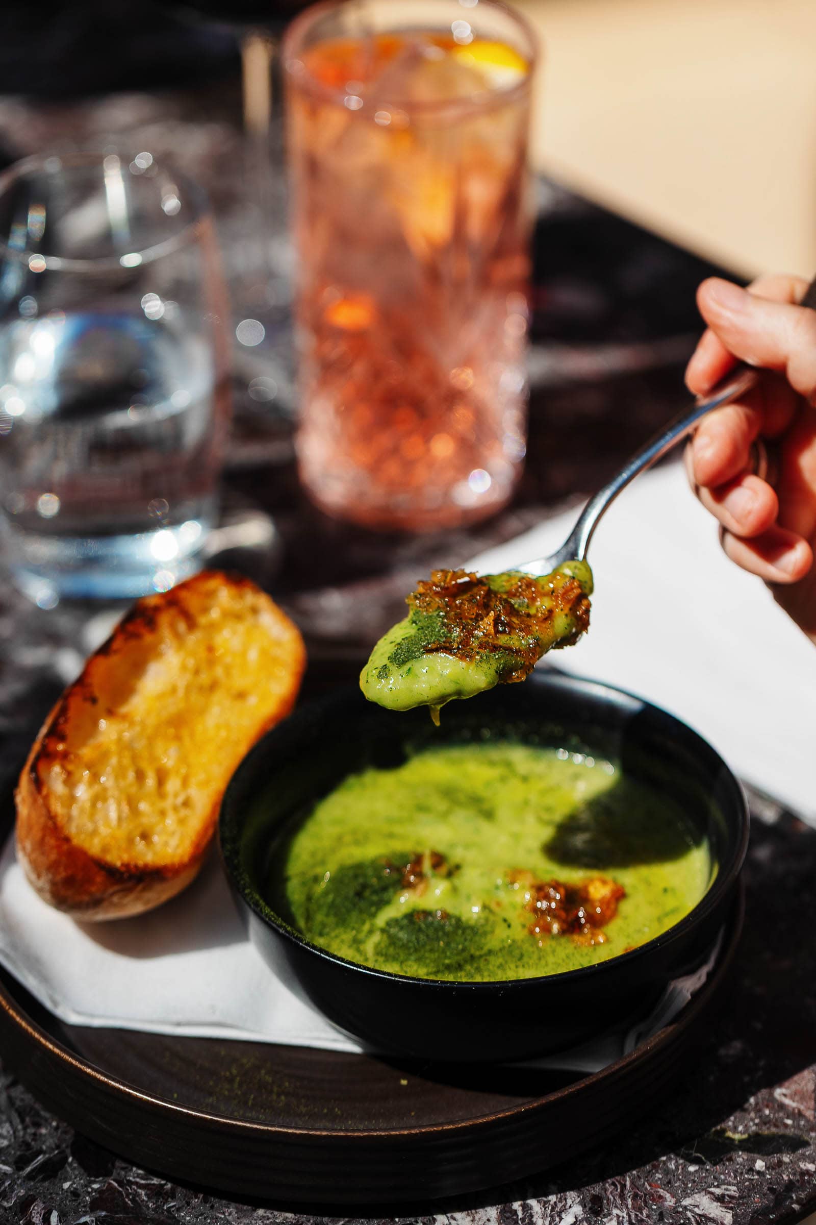 A spoonful of pea soup being held above the bowl taken by a Rutland Food Photographer