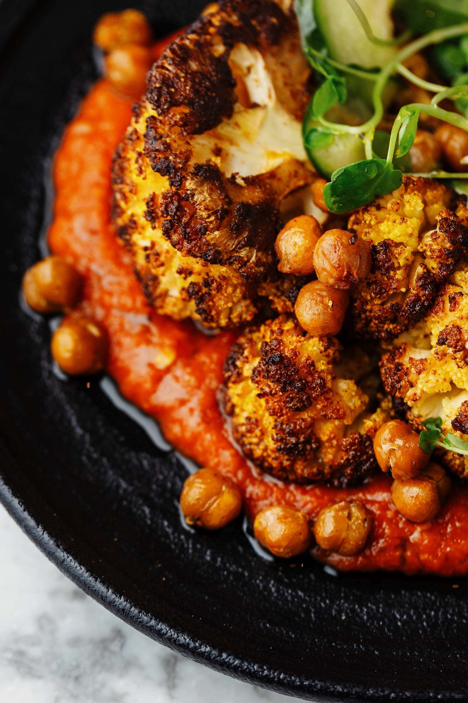 Baked cauliflower on a tomato sauce with chickpeas