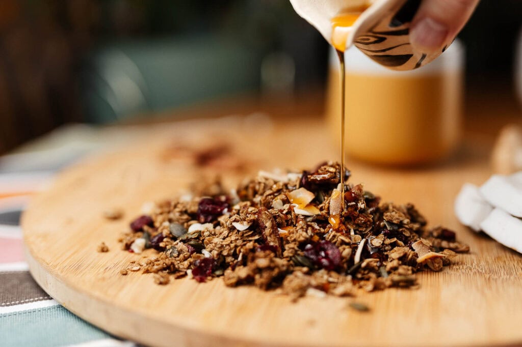 Healthy granola with honey drizzle on wooden board, close-up, food photography by Rutland Food Photographer for restaurant and cafe marketing.