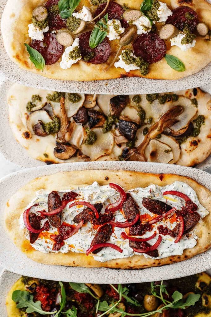 Delicious gourmet pizzas topped with fresh herbs, mushrooms, cured meats, and vibrant vegetables, captured by Rutland food photographer for perfect food presentation.