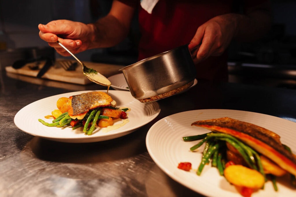 Freshly cooked fish dishes with vibrant vegetables, expertly plated by a Rutland food photographer for a professional culinary presentation.