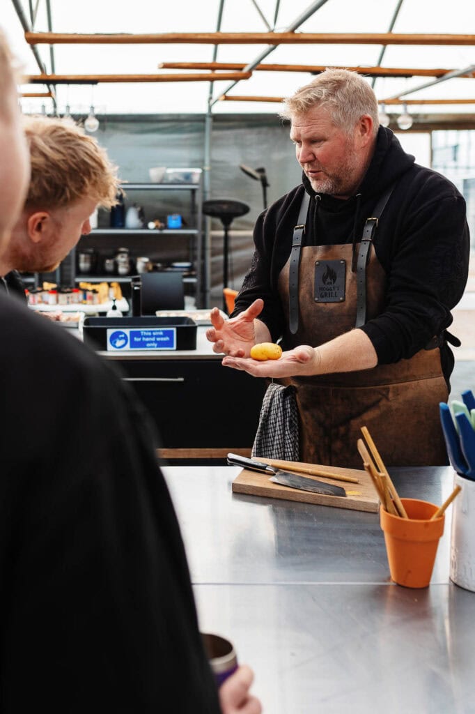 Freshly cooked potato being explained by a chef at Hoggy's Grill in a bright, modern kitchen showcasing professional food photography for Rutland food blogs.