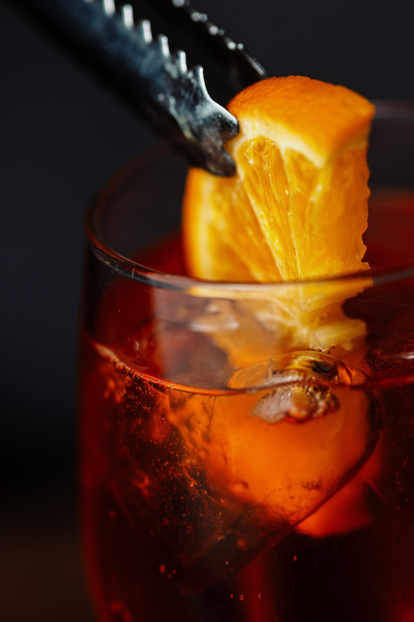 Vibrant red cocktail with a fresh orange slice garnish, captured in close-up by Rutland food photographer, showcasing professional food and beverage photography.