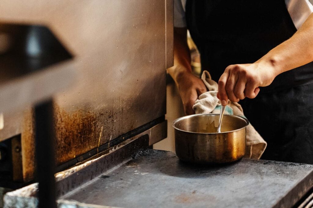 Richmond food photographer capturing culinary dishes in professional kitchen setting with focus on cooking process and food presentation.