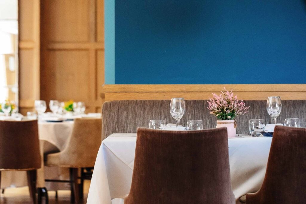 Stylish dining area with neatly arranged tables, white tablecloths, and glassware in a Rutland restaurant.