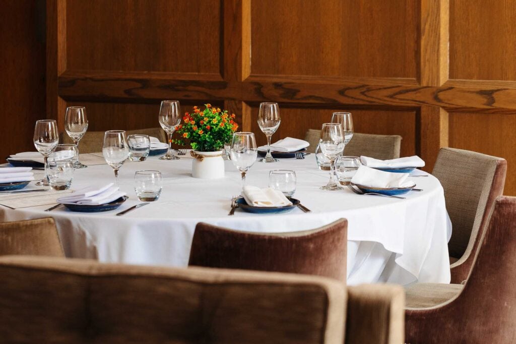 Formal dining table arranged with glassware, napkins, and a floral centrepiece, perfect for events or fine dining in Rutland.