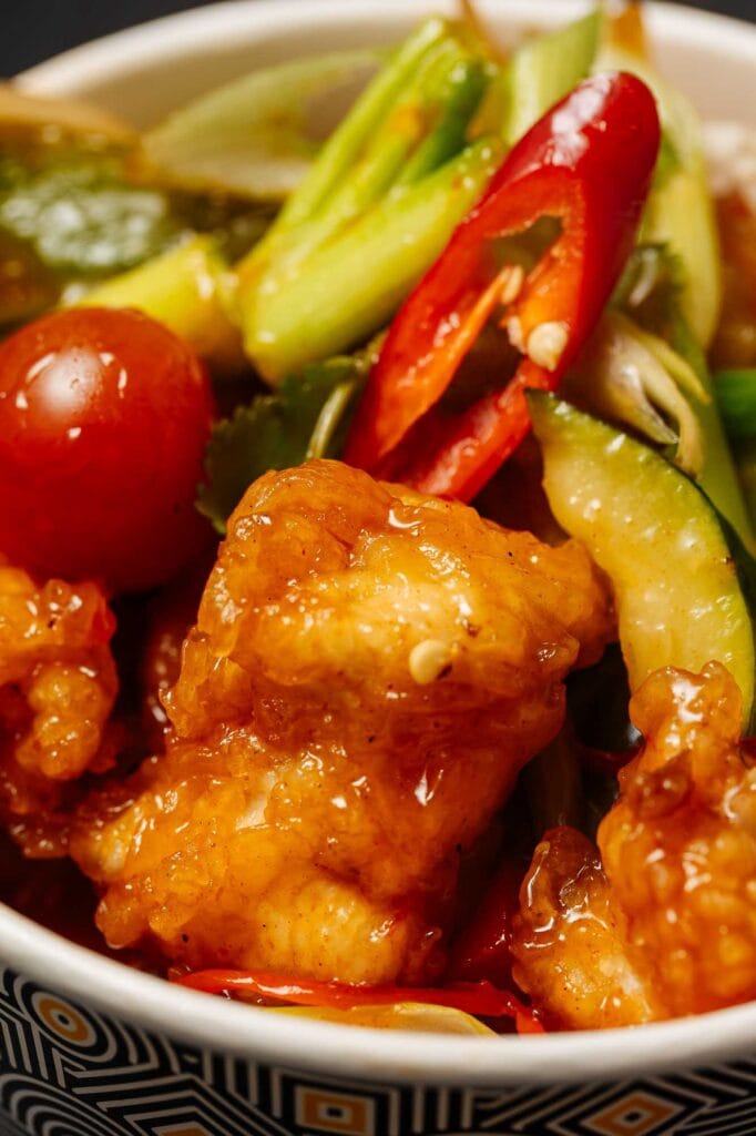 Inspired chicken and vegetable stir-fry featuring crispy chicken pieces, colourful peppers, cherry tomatoes, and fresh greens, perfect for a healthy meal.