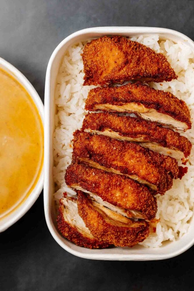 Delicious crispy chicken katsu served over fluffy white rice, showcasing golden-brown breaded chicken cutlets perfect for food photography.