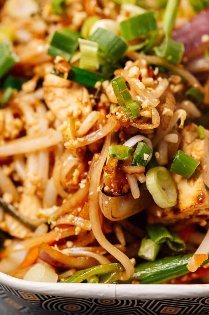 Delicious stir-fried noodles with fresh vegetables, tofu, and sesame seeds, showcasing vibrant colours and textures, perfect for Asian cuisine lovers.