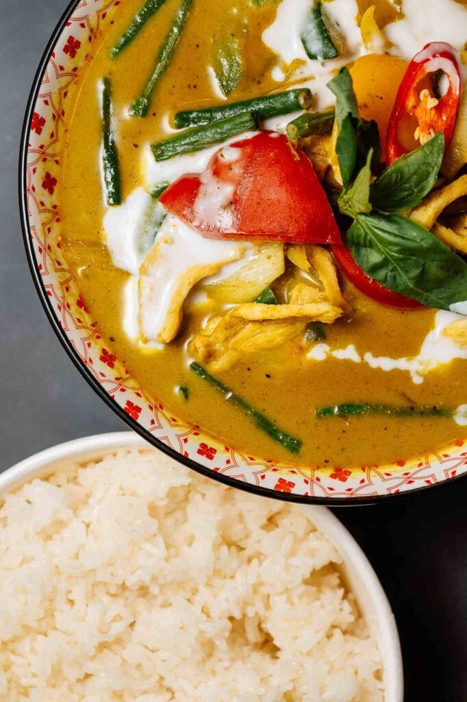 Delicious Thai green curry featuring chicken, fresh vegetables, and aromatic herbs served with fluffy white rice. Perfect for authentic Asian cuisine lovers seeking a flavourful meal.
