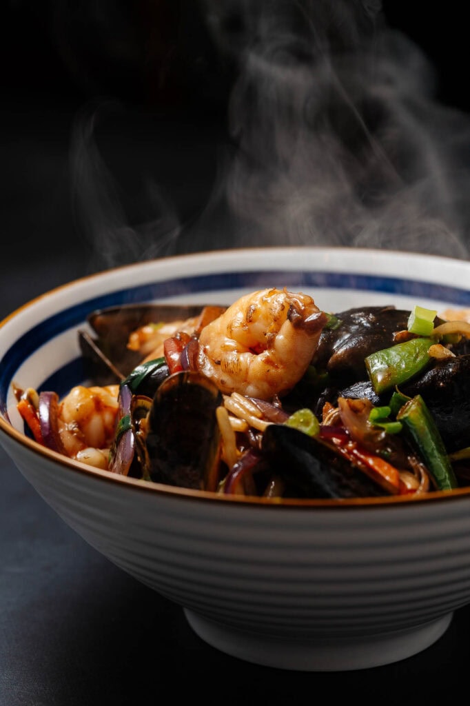 Fresh seafood stir-fry with shrimp, mussels, and vegetables served in a white bowl, captured by Rutland food photographer. Perfect for promoting seafood dishes and culinary photography.