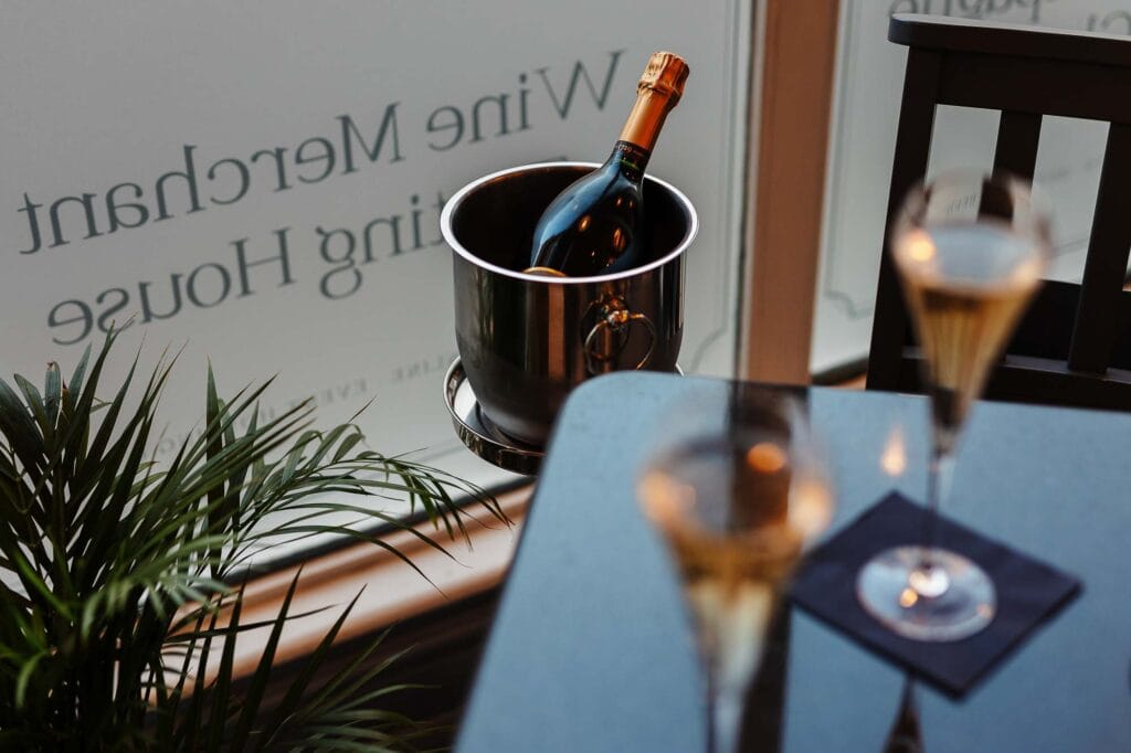 Elegant champagne bottle in an ice bucket with two glasses on a table, capturing a celebratory moment at Rutland Food Photographer.