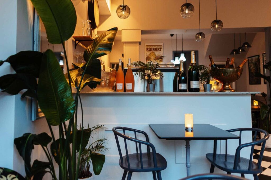 Stylish café interior with a bar counter, potted plants, and ambient lighting, perfect for a relaxing dining experience in Rutland.