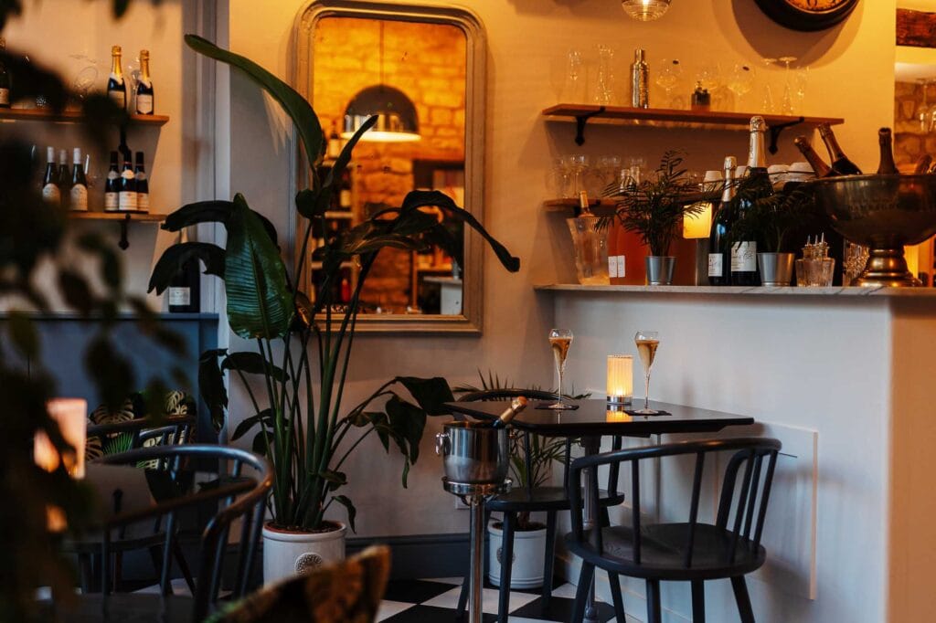 An inviting restaurant interior featuring warm lighting, stylish furniture, and decorative plants, perfect for a memorable dining experience in Rutland.