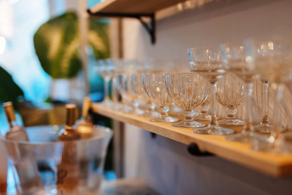 Up of assorted crystal glasses arranged on a wooden shelf, showcasing professional food and drink photography for Rutland-based culinary clients.