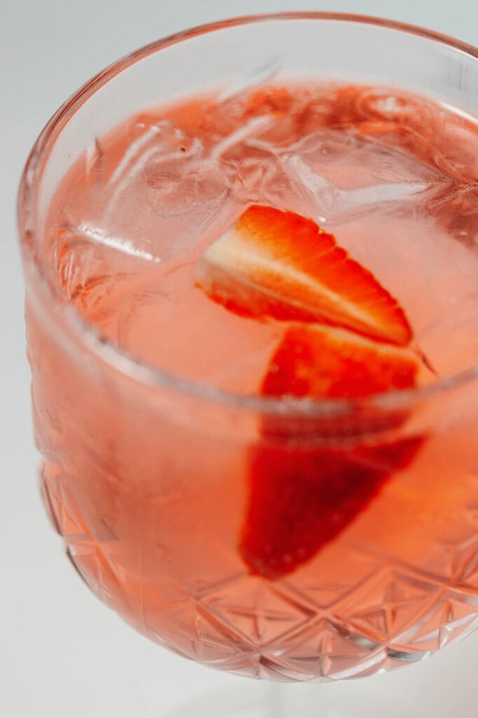 Refreshing strawberry gin cocktail with fresh strawberries and ice in an elegant glass, perfect for summer drinks at Indian restaurant events.