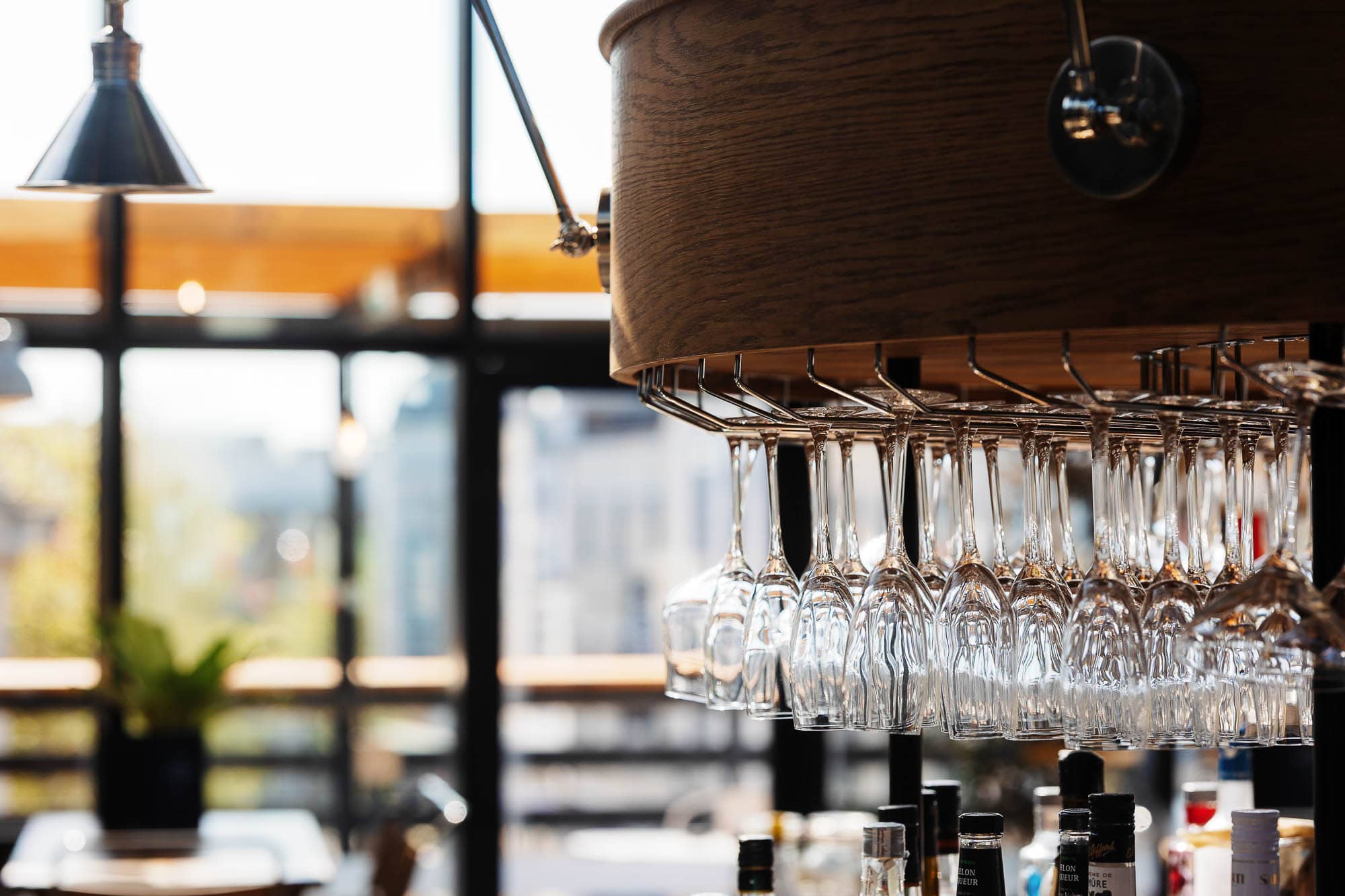 Stylish food photography of a bar area showcasing hanging wine glasses and ambient lighting, captured by Rutland Food Photographer for a professional food and beverage shoot.