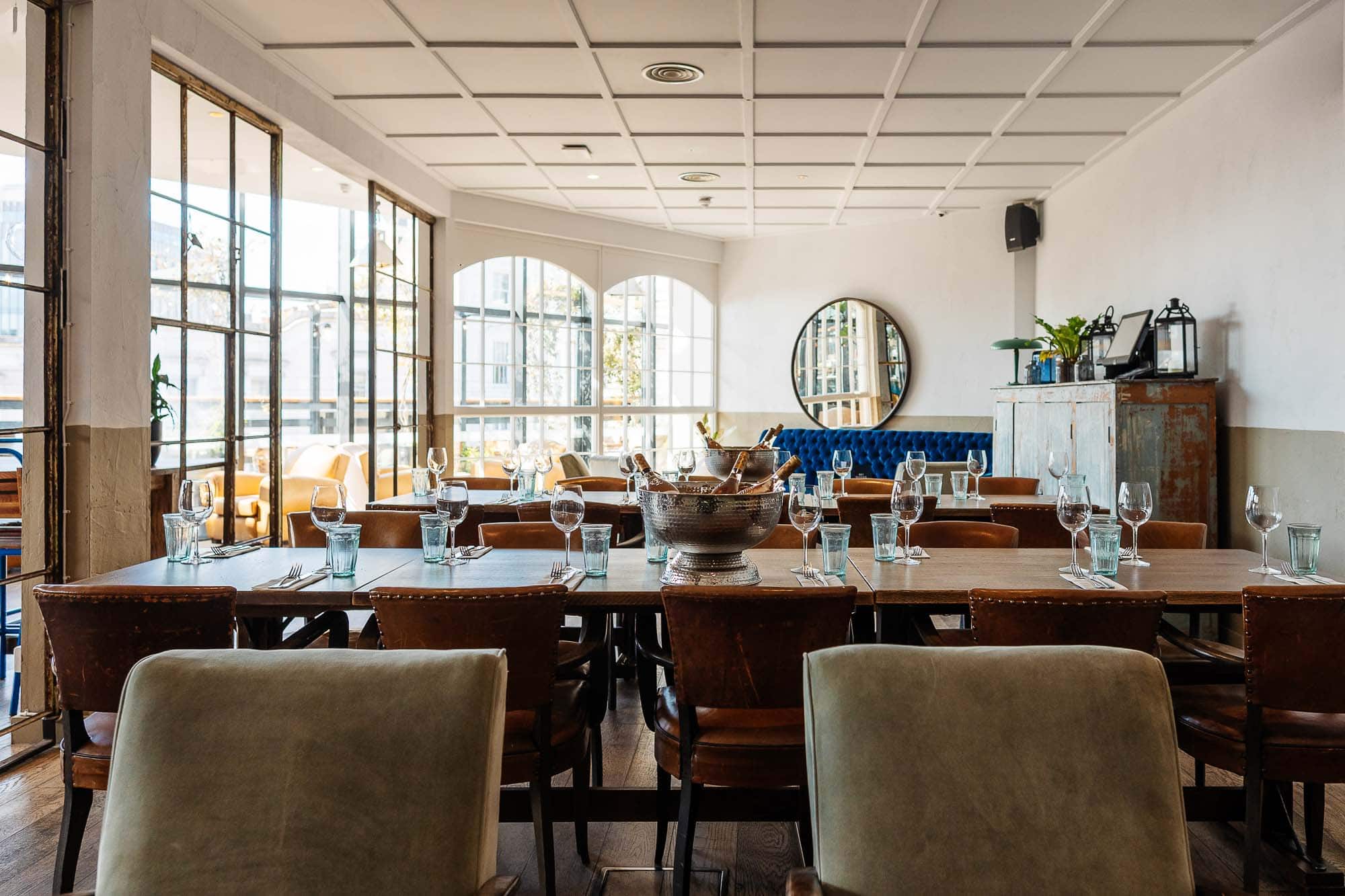 Modern restaurant interior with large windows, wooden tables, and stylish decor, ideal for food photography and culinary events in Rutland.